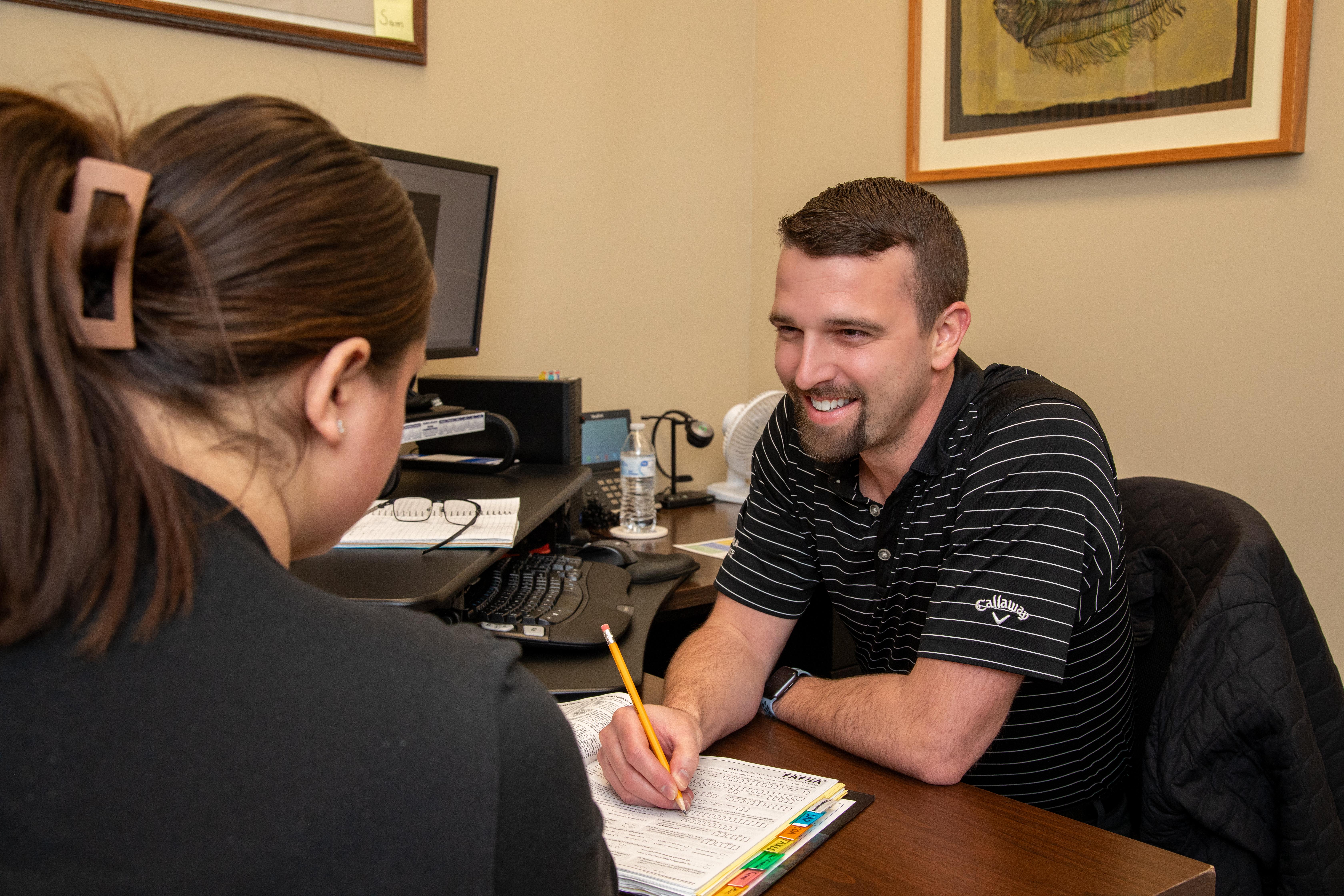 A financial aid officer assists a student with the FAFSA